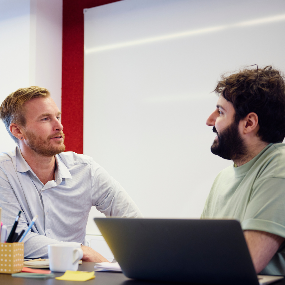 To mannlige kolleger som sitter og prater