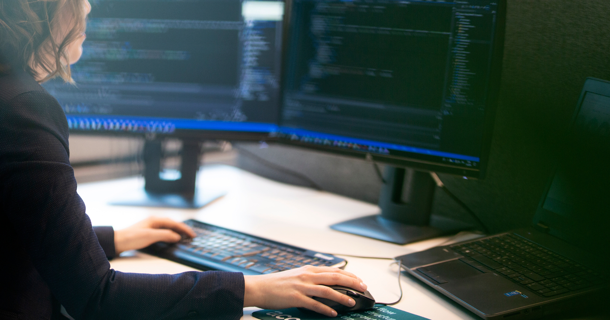 Dame foran pc skjermen som koder