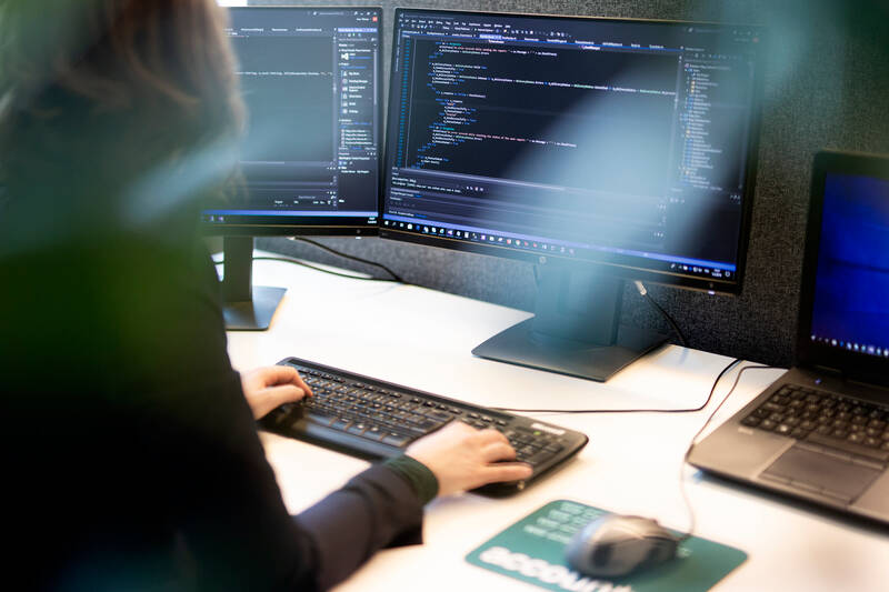 Dame som sitter foran en pc og koder