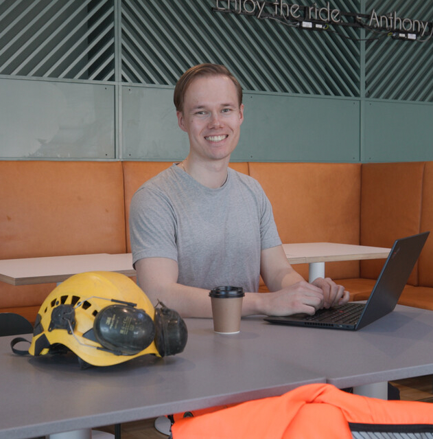 Mann med laptop som smiler