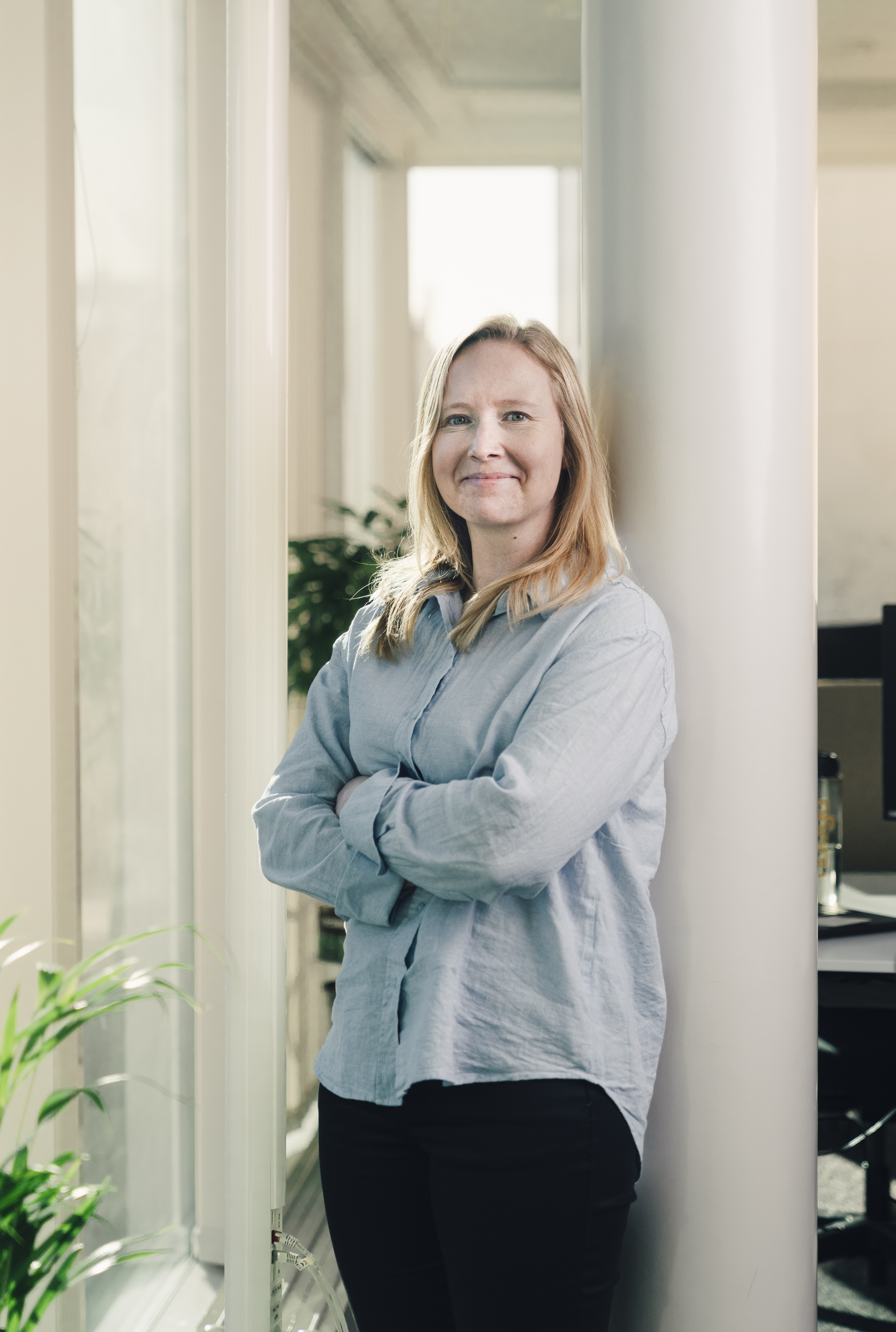 Dame som lener seg mot en stang