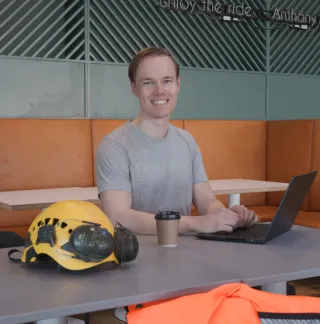 Mann med laptop som smiler