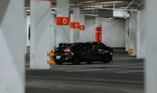 En svart bil i parkeringshus
