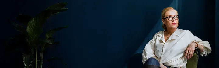 Kvinne som sitter i en stol og ser til høyre