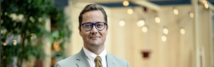 Mann med briller som ser mot deg 