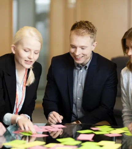 Mennesker som står over et bord med post-it-lapper