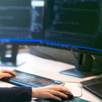 Dame foran pc skjermen som koder