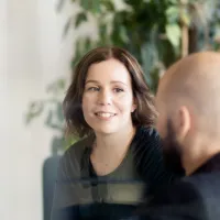 En mann og en kvinne som prater. Kvinnen ansikt er synlig og ser ut som hun lytter