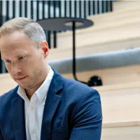 Mann fokuser med pc sitter i et åpent auditorium