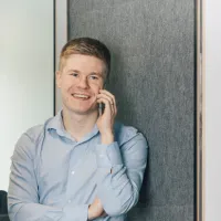 Man som prater i telefonen i en lydtett telefoncelle i åpent landskap