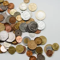 Masse mynter som ligger spredt utover et bord