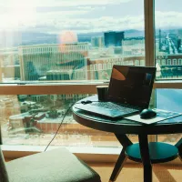 Pc på et bord  på hotellrom  med utsikt over en by