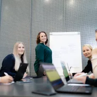 Møte med like mange kvinner og menn. En av kvinnene leder møtet.